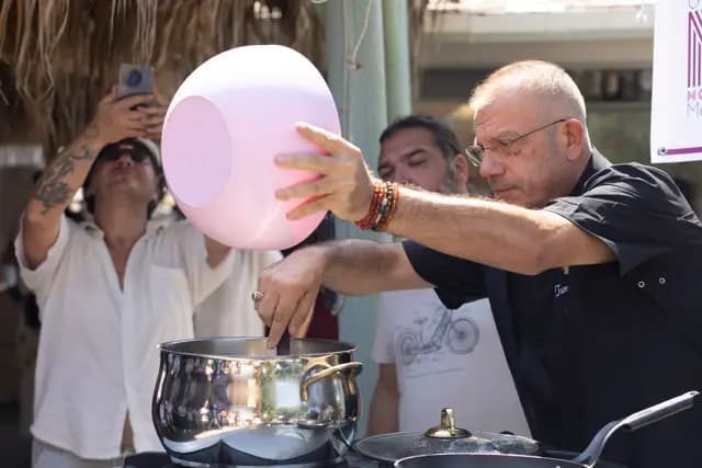 Şef pembe kâseyi büyük tencereye boşaltırken hareket doruk noktasında donuyor.
