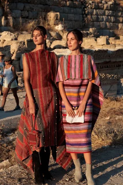 El dokuması desenli iki görünüm, Knidos'un taş duvarları önünde yan yana.